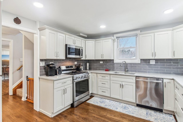 kitchen featuring light countertops, appliances with stainless steel finishes, dark wood-style flooring, and a sink