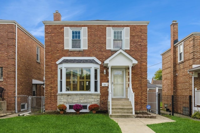 view of front of house with brick siding, entry steps, a gate, fence, and a front lawn