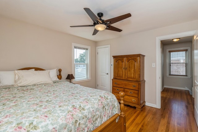 bedroom with ceiling fan, multiple windows, wood finished floors, and baseboards