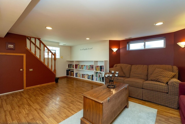 living area with stairs, baseboards, a wealth of natural light, and light wood-style floors