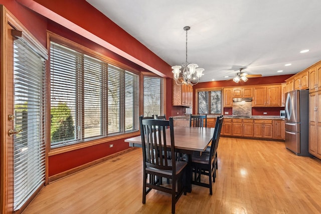 dining space with baseboards, plenty of natural light, and light wood-style floors