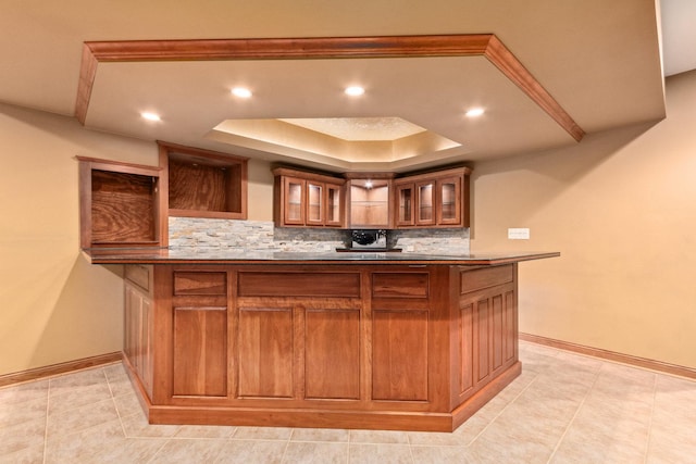 bar featuring recessed lighting, baseboards, decorative backsplash, and a raised ceiling