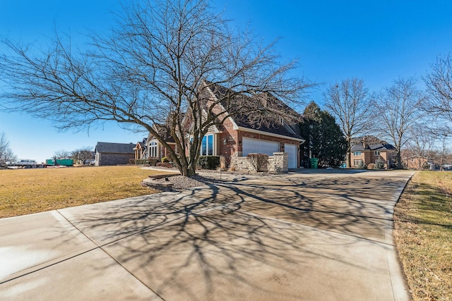 view of front facade featuring a garage, a front yard, concrete driveway, and brick siding