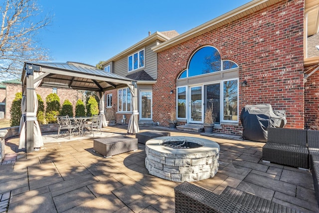 view of patio / terrace featuring entry steps, an outdoor fire pit, outdoor dining area, a gazebo, and grilling area