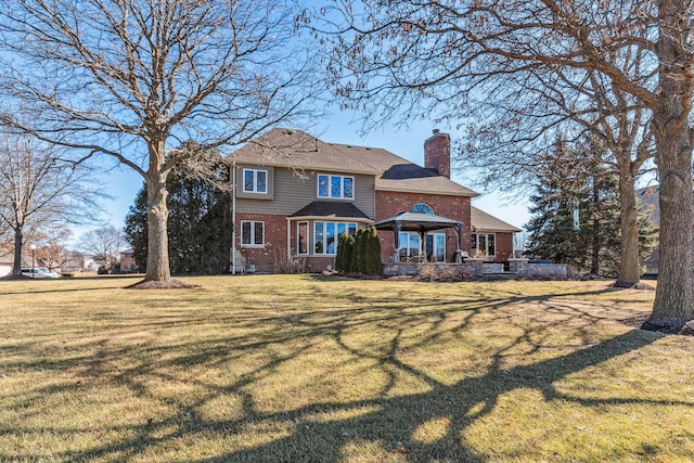 rear view of house featuring brick siding, a lawn, a chimney, and a gazebo