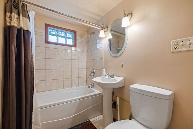 full bathroom featuring toilet, shower / bath combo with shower curtain, and a sink