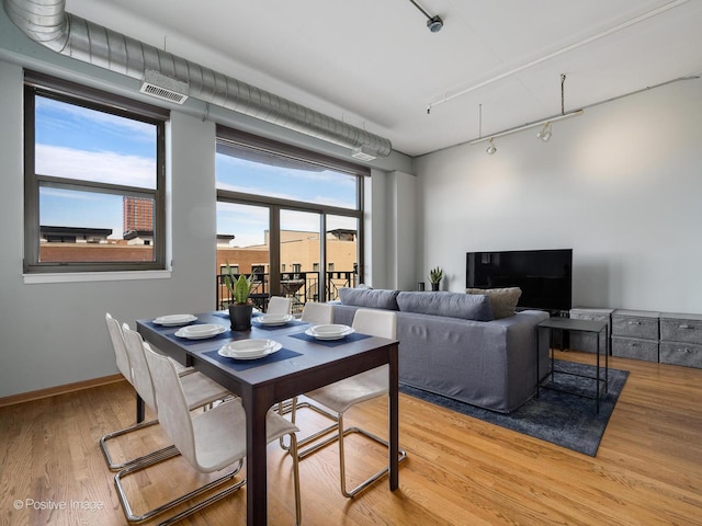 dining space featuring visible vents, baseboards, track lighting, and light wood finished floors