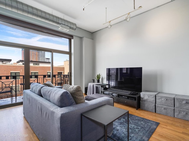 living room with track lighting, wood finished floors, and visible vents