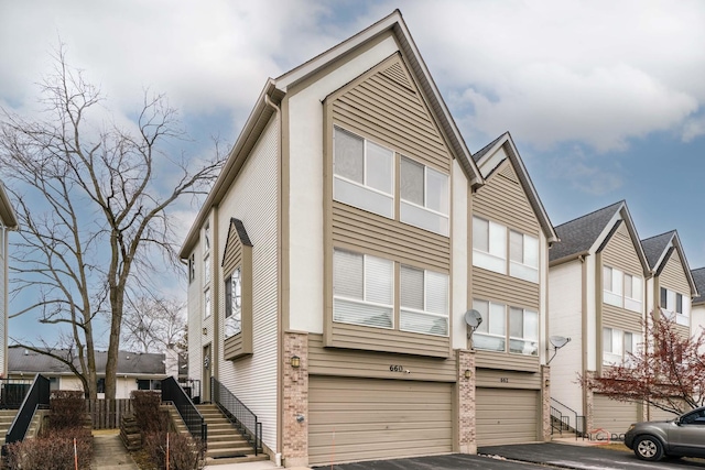 view of front of house featuring driveway, an attached garage, and stairs