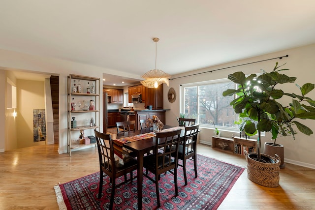 dining room featuring light wood-type flooring and baseboards