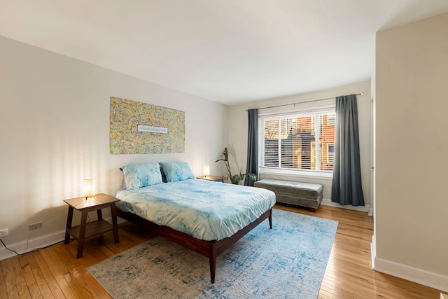 bedroom with baseboards and hardwood / wood-style flooring