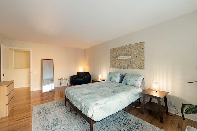 bedroom featuring baseboards and light wood finished floors