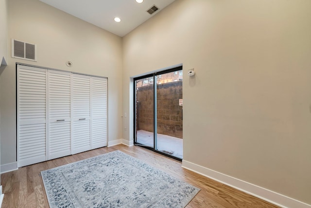 unfurnished bedroom with access to outside, visible vents, baseboards, and wood finished floors