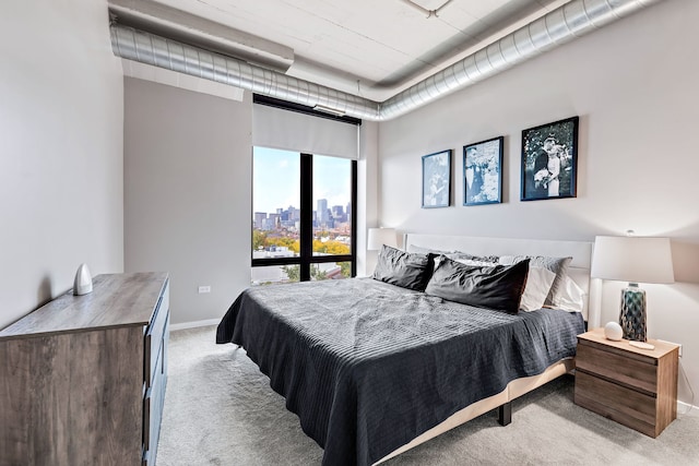 carpeted bedroom with a view of city and baseboards