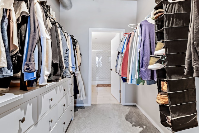 spacious closet featuring light colored carpet