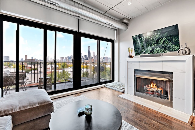 living area with visible vents, wood finished floors, and a tile fireplace