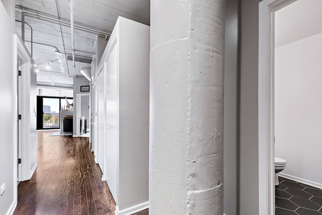 hallway with baseboards and wood finished floors