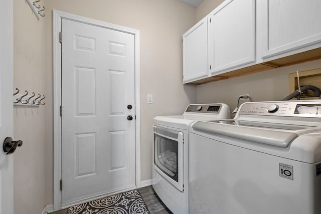 laundry room featuring cabinet space, dark wood-style floors, baseboards, and washing machine and clothes dryer