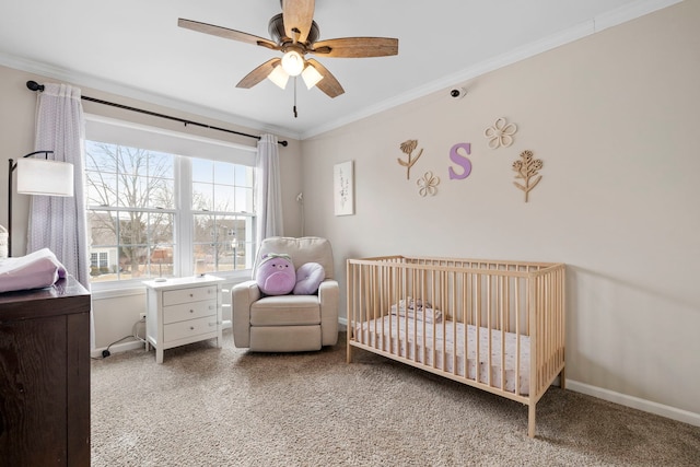 bedroom featuring baseboards, a crib, carpet, and crown molding