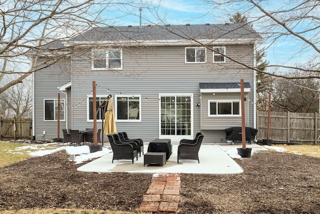 rear view of house with a patio, an outdoor living space, and fence