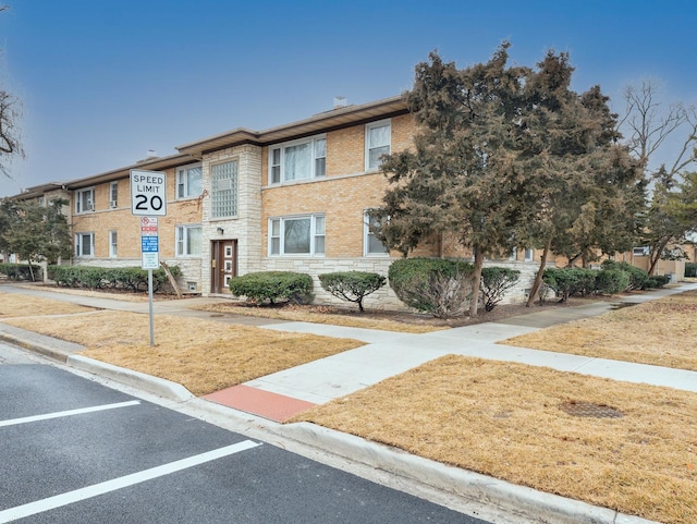 townhome / multi-family property featuring stone siding and brick siding