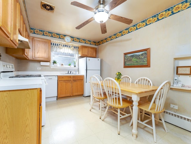 kitchen with a baseboard heating unit, white appliances, light floors, and light countertops