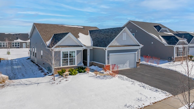 view of front of house featuring driveway, an attached garage, a residential view, and roof with shingles