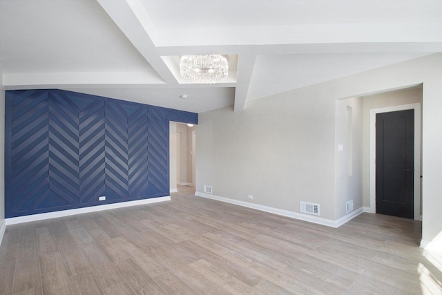 unfurnished room with light wood finished floors, baseboards, visible vents, an inviting chandelier, and beam ceiling