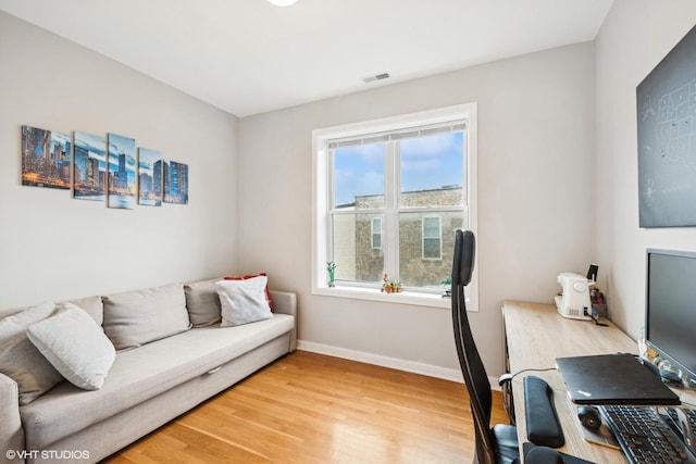 home office featuring baseboards, visible vents, and light wood finished floors