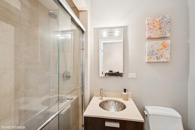 full bathroom featuring toilet, a stall shower, and vanity