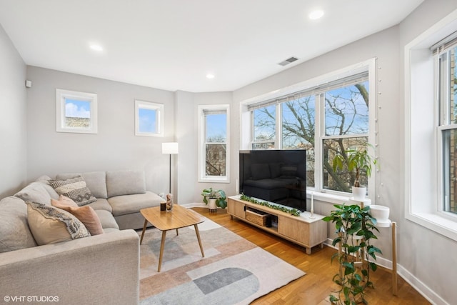 living room with light wood-style floors, recessed lighting, visible vents, and baseboards