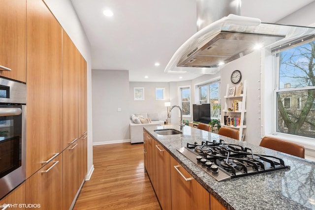 kitchen with modern cabinets, open floor plan, dark stone countertops, stainless steel appliances, and a sink