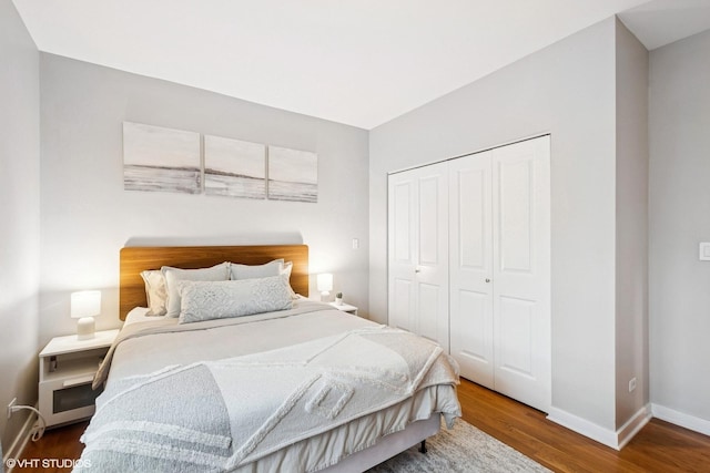 bedroom featuring a closet, baseboards, and wood finished floors