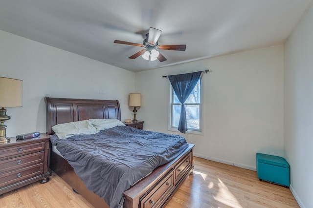 bedroom featuring baseboards, light wood-style floors, and a ceiling fan