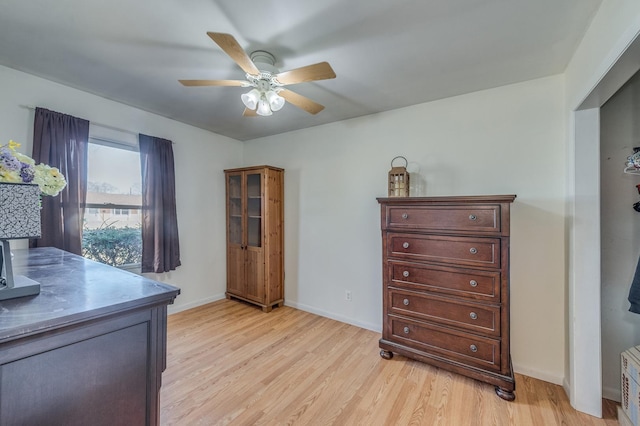 interior space with ceiling fan, baseboards, and light wood-style flooring