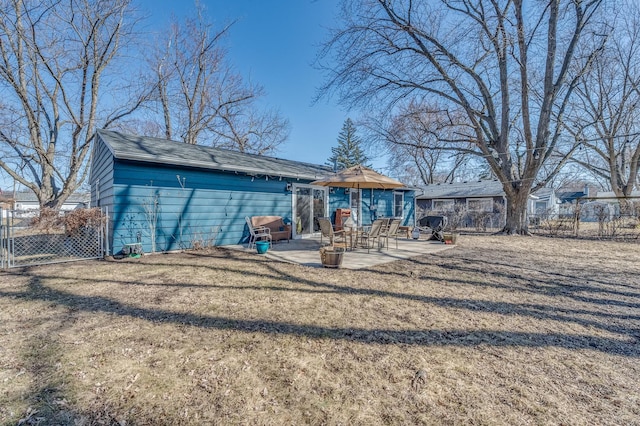 back of property with a yard, fence, and a patio area