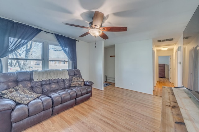 living room with baseboards, a ceiling fan, visible vents, and light wood-type flooring