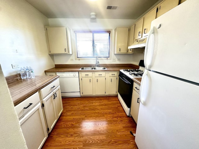 kitchen with light wood finished floors, visible vents, a sink, white appliances, and under cabinet range hood