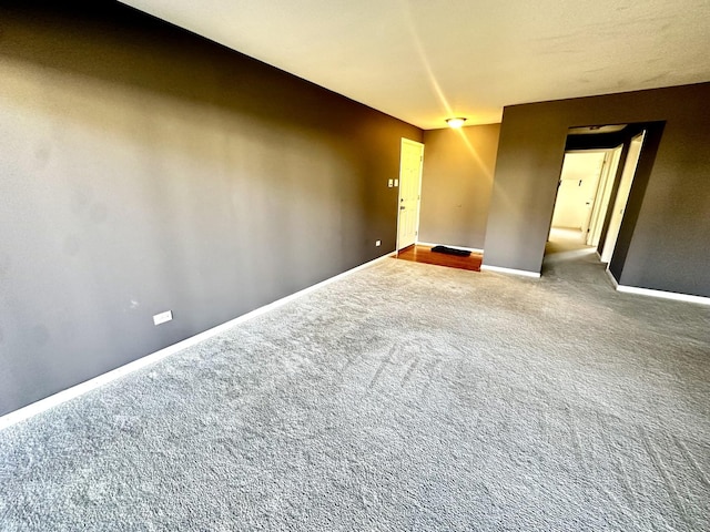 carpeted spare room featuring baseboards