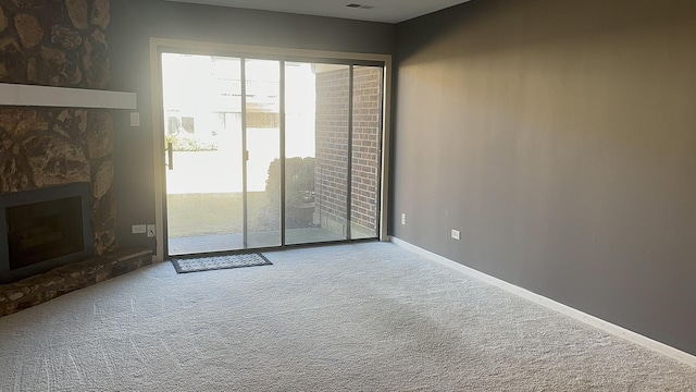 unfurnished room with a fireplace, baseboards, and carpet flooring