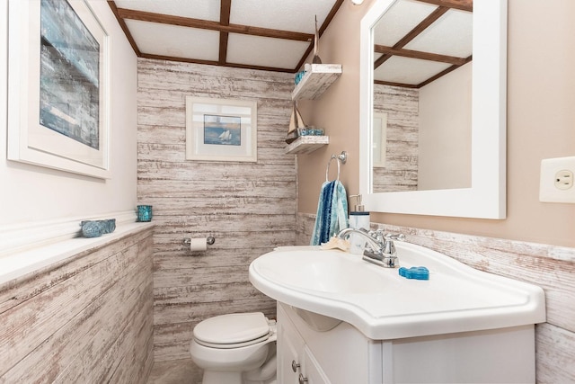 bathroom featuring toilet, a wainscoted wall, and vanity