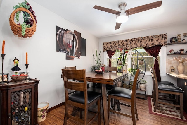 dining area featuring a ceiling fan, baseboards, and wood finished floors