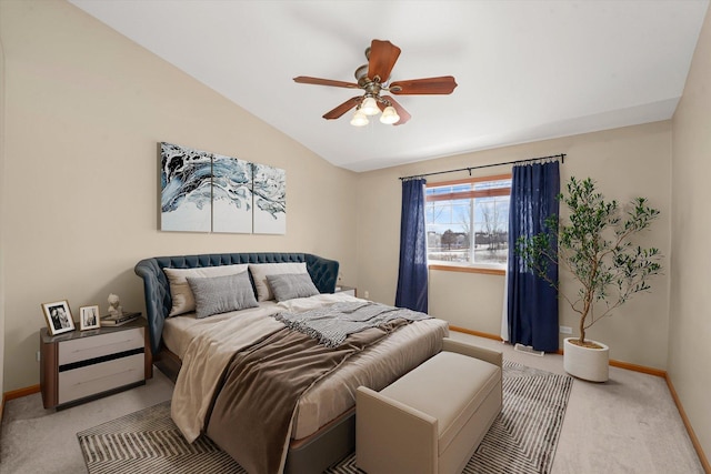 bedroom featuring a ceiling fan, light carpet, vaulted ceiling, and baseboards