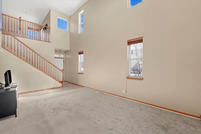 living area featuring stairway, plenty of natural light, and carpet flooring