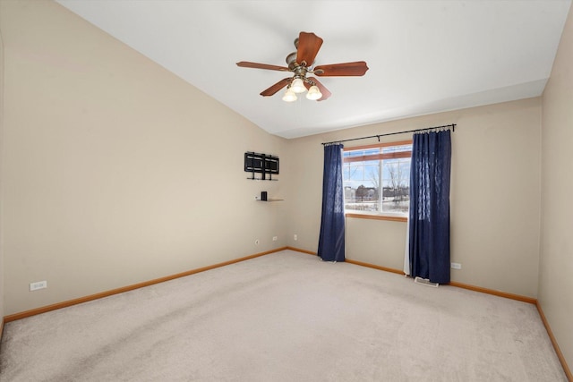 unfurnished room with a ceiling fan, lofted ceiling, baseboards, and carpet