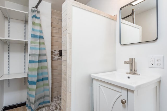 bathroom featuring a tile shower and vanity