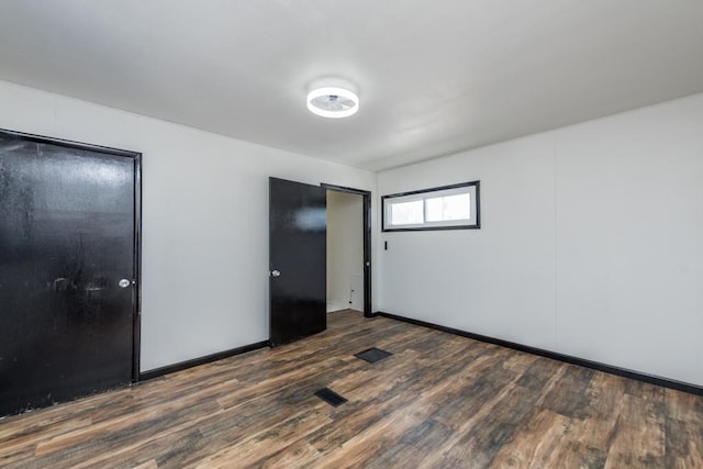 unfurnished bedroom featuring baseboards and dark wood finished floors