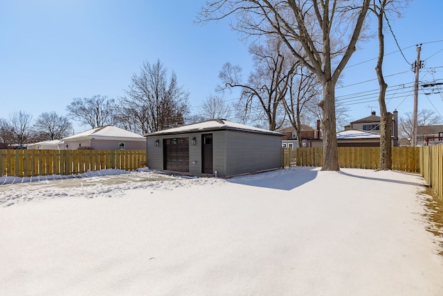 exterior space featuring a garage, fence private yard, and an outdoor structure