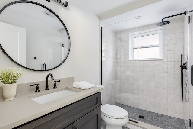 bathroom featuring a stall shower, vanity, and toilet