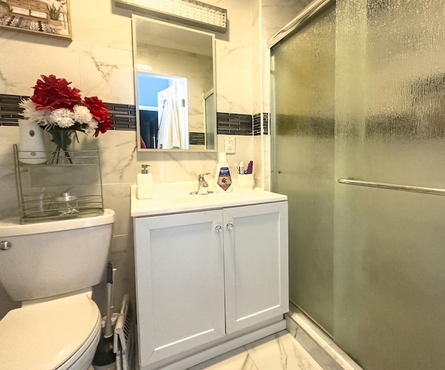 full bath featuring toilet, marble finish floor, a shower stall, and vanity